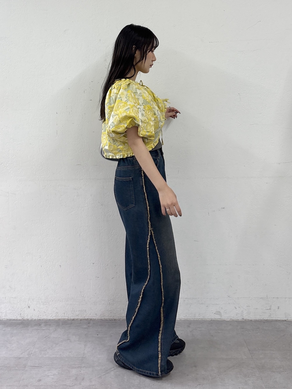 イエロー系のシャツ/ブラウス、ブルー系のデニムパンツ、シルバー系のトートバッグを着用したレディースの夏コーディネートの3枚目の写真