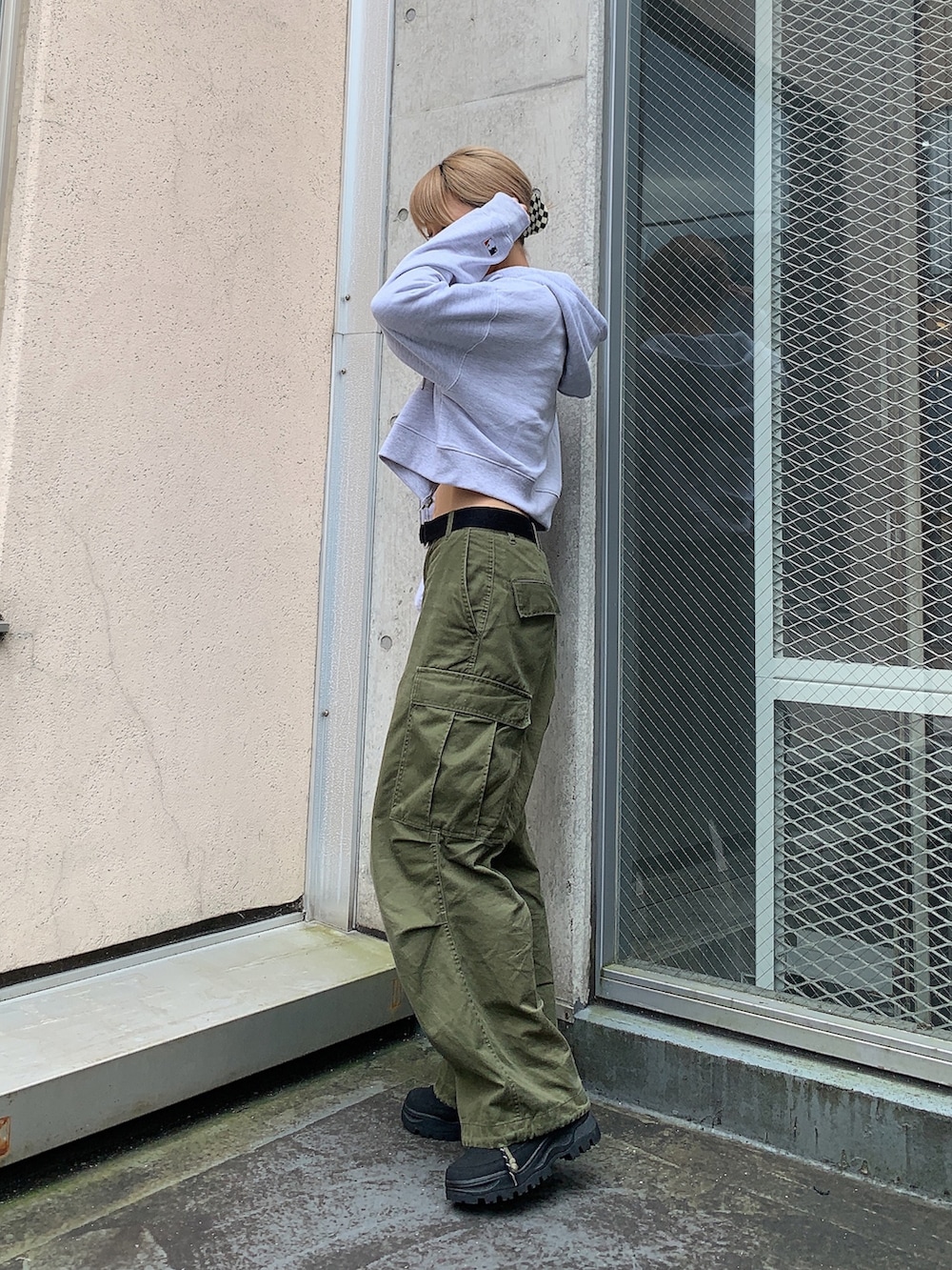 グリーン系のカーゴパンツ、グレー系のパーカー、ブラック系のTシャツ/カットソーを着用したレディースの秋コーディネートの2枚目の写真