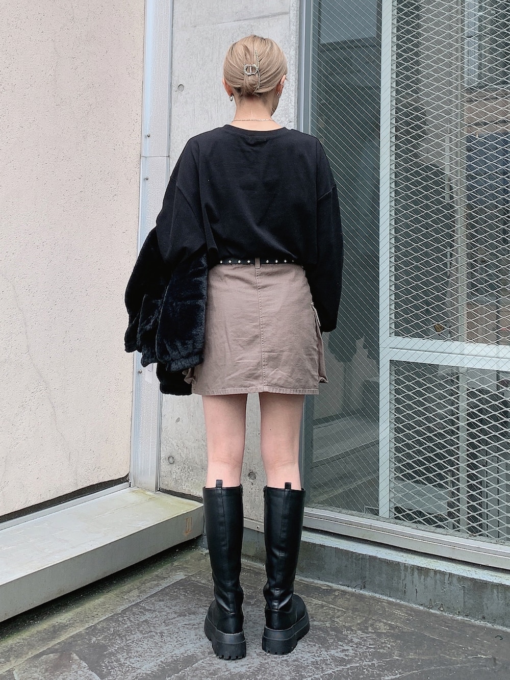 ブラック系のブルゾン、ブラック系のTシャツ/カットソー、グリーン系のスカートを着用したレディースの秋コーディネートの4枚目の写真