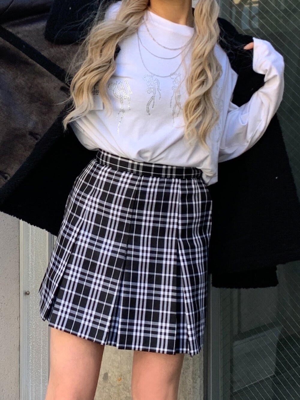 ホワイト系のTシャツ/カットソー、ブラック系のムートンコート、ブラック系のスニーカーを着用したレディースの秋コーディネートの4枚目の写真