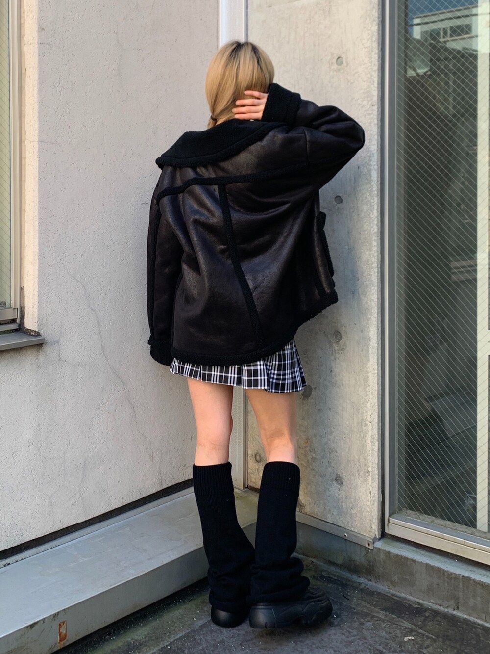 ホワイト系のTシャツ/カットソー、ブラック系のムートンコート、ブラック系のスニーカーを着用したレディースの秋コーディネートの3枚目の写真