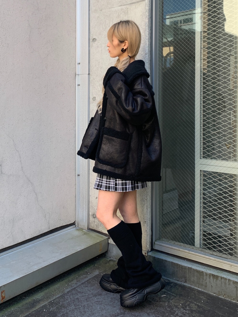 ホワイト系のTシャツ/カットソー、ブラック系のムートンコート、ブラック系のスニーカーを着用したレディースの秋コーディネートの2枚目の写真
