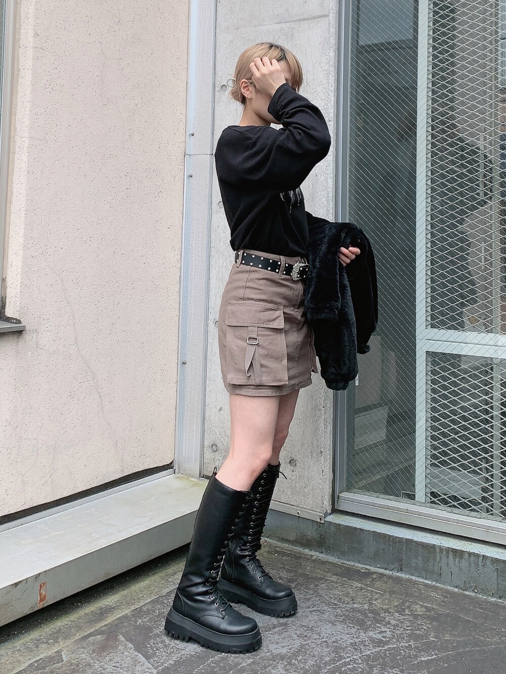 ブラック系のブルゾン、ブラック系のTシャツ/カットソー、グリーン系のスカートを着用したレディースの秋コーディネートの3枚目の写真