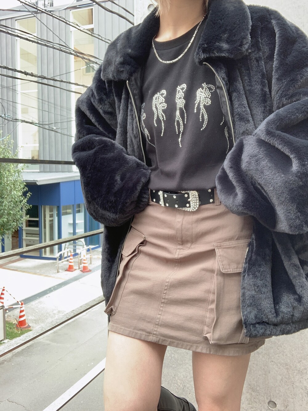 ブラック系のブルゾン、ブラック系のTシャツ/カットソー、グリーン系のスカートを着用したレディースの秋コーディネートの5枚目の写真