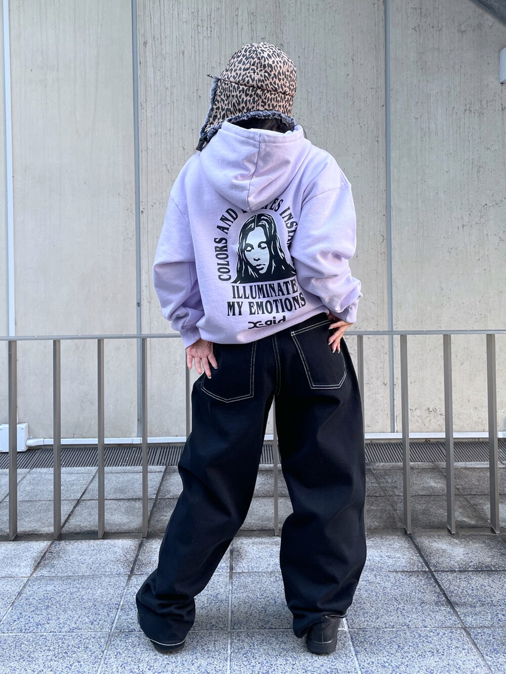 ブラック系のデニムパンツ、パープル系のパーカー、ブラウン系のキャップを着用したレディースの冬コーディネートの2枚目の写真