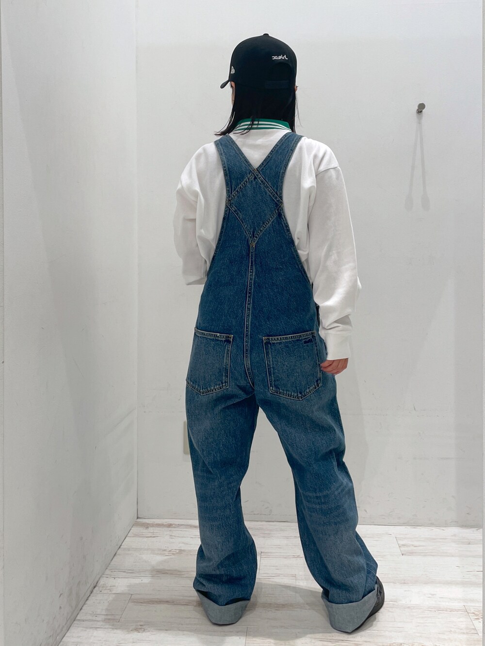 ホワイト系のTシャツ/カットソー、ブルー系のサロペット/オーバーオール、ブラック系のキャップを着用したレディースの春コーディネートの2枚目の写真