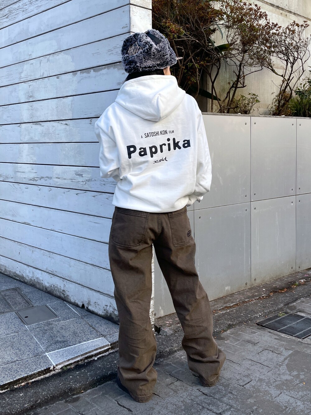 ホワイト系のパーカー、ブラウン系のデニムパンツ、ブラウン系のキャップを着用したレディースの冬コーディネートの2枚目の写真