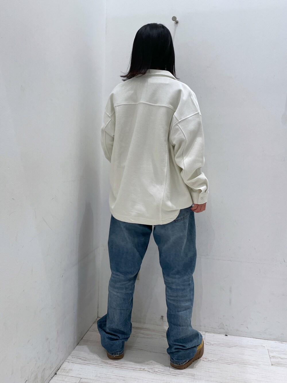 グレー系のTシャツ/カットソー、ホワイト系のシャツ/ブラウス、ブルー系のデニムパンツを着用したレディースの春コーディネートの2枚目の写真