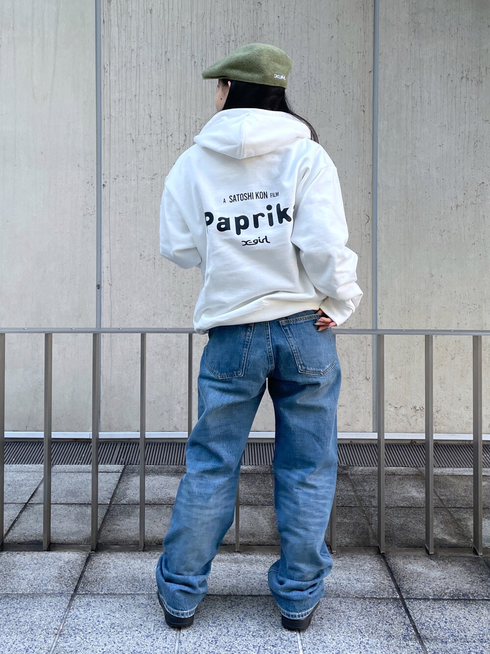 ホワイト系のパーカー、ブルー系のデニムパンツ、グリーン系のハンチング/ベレー帽を着用したレディースの冬コーディネートの2枚目の写真