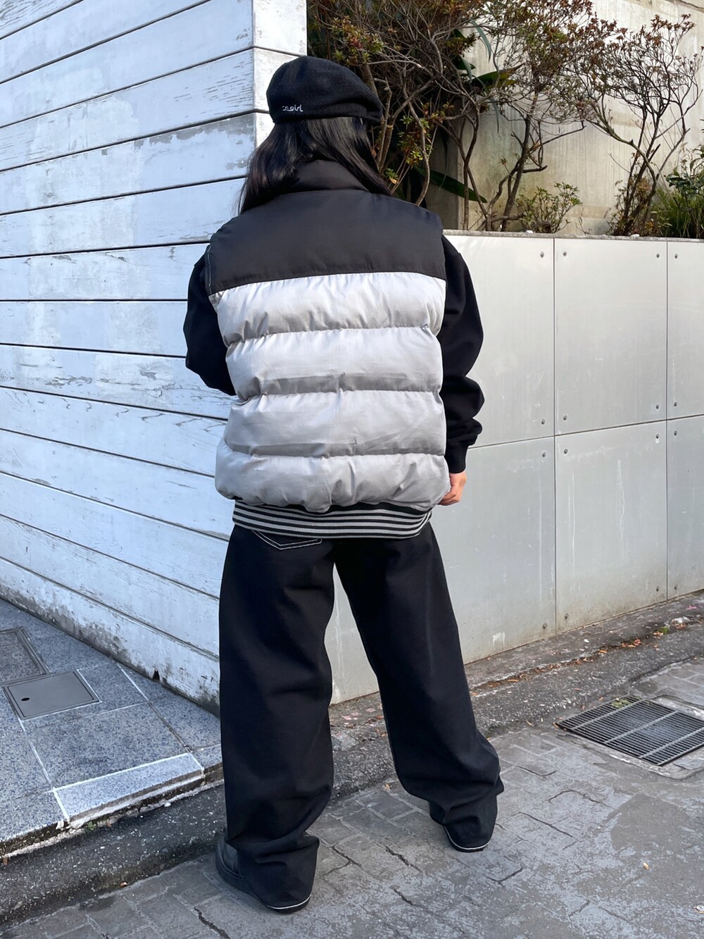 ブラック系のスウェット、ブラック系のベスト、ブラック系のデニムパンツを着用したレディースの冬コーディネートの2枚目の写真