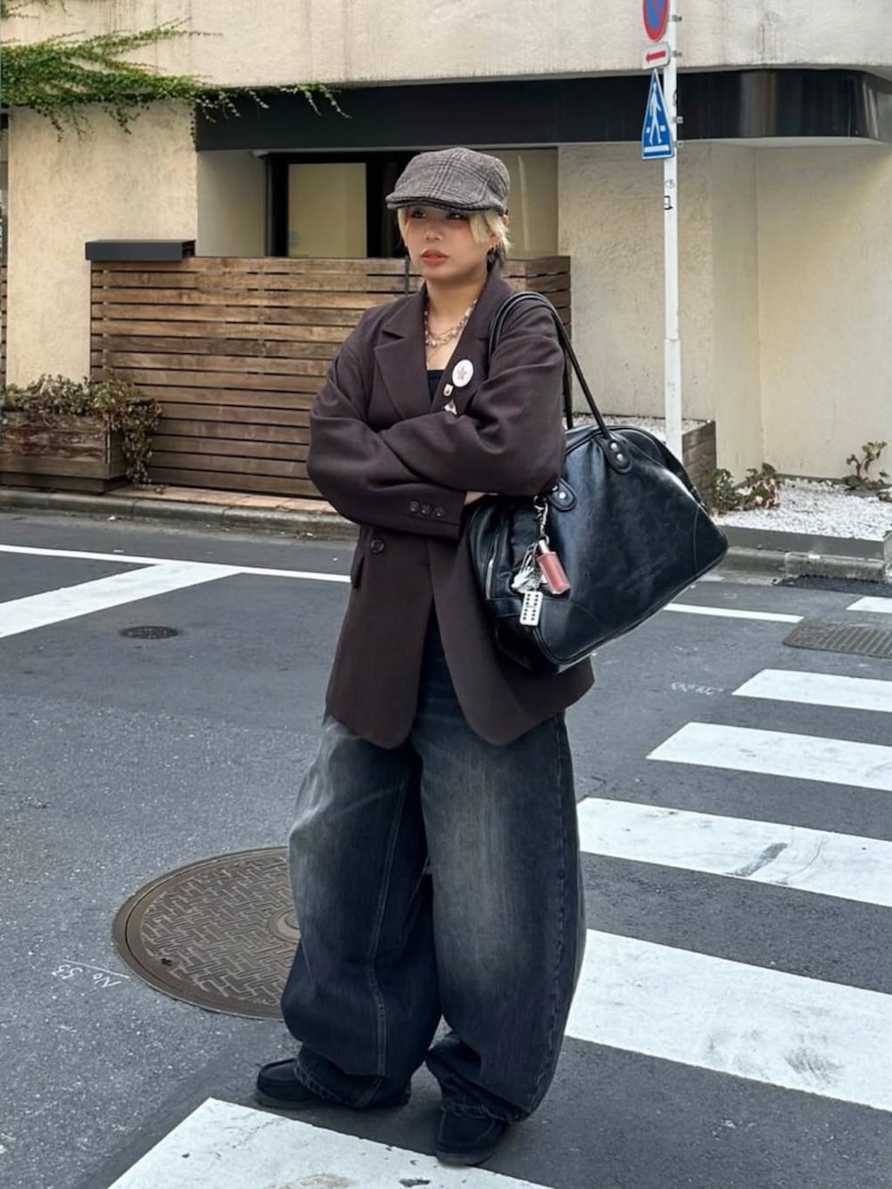 ブラック系のボストンバッグ、ブラウン系のテーラードジャケット、ブラック系のデニムパンツを着用したレディースの秋コーディネートの4枚目の写真