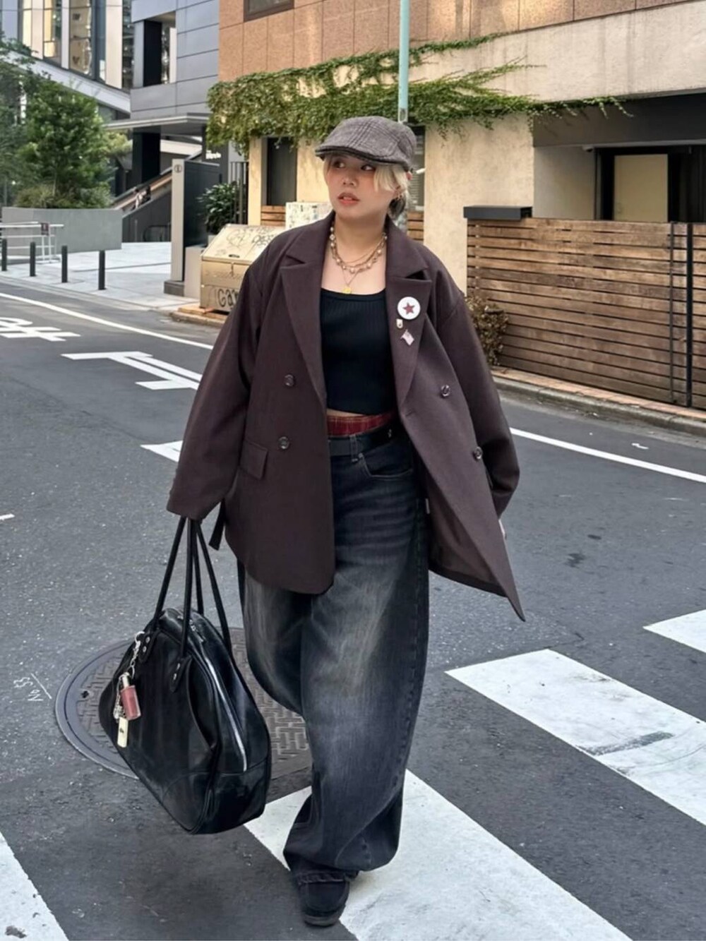 ブラック系のボストンバッグ、ブラウン系のテーラードジャケット、ブラック系のデニムパンツを着用したレディースの秋コーディネートの3枚目の写真