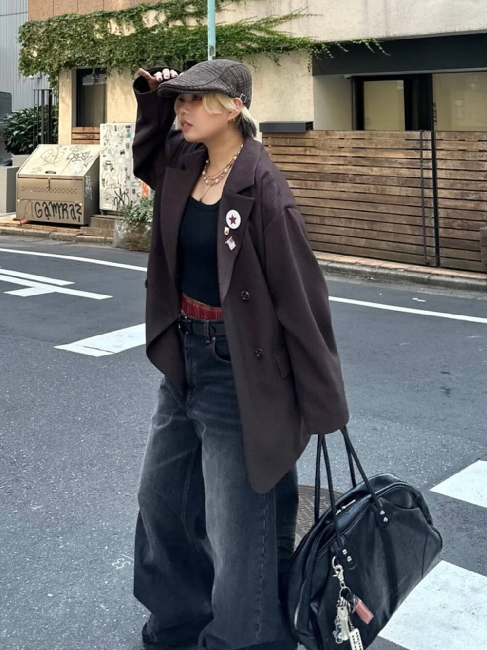 ブラック系のボストンバッグ、ブラウン系のテーラードジャケット、ブラック系のデニムパンツを着用したレディースの秋コーディネートの5枚目の写真