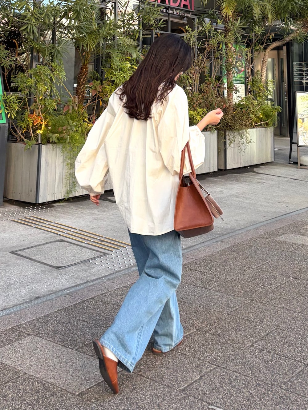 ホワイト系のシャツ/ブラウス、ブルー系のデニムパンツ、ブラウン系のパンプスを着用したレディースの冬コーディネートの2枚目の写真