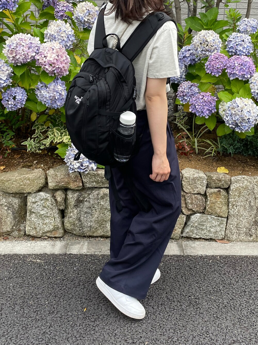 ベージュ系のTシャツ/カットソー、ブルー系のその他パンツ、ホワイト系のスニーカーを着用したレディースの夏コーディネートの3枚目の写真