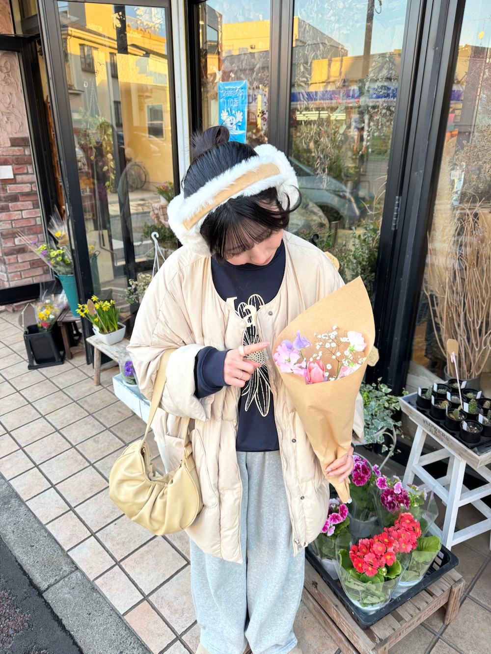 ブルー系のスウェット、ベージュ系のダウンジャケット/コート、イエロー系のトートバッグを着用したレディースの冬コーディネートの4枚目の写真