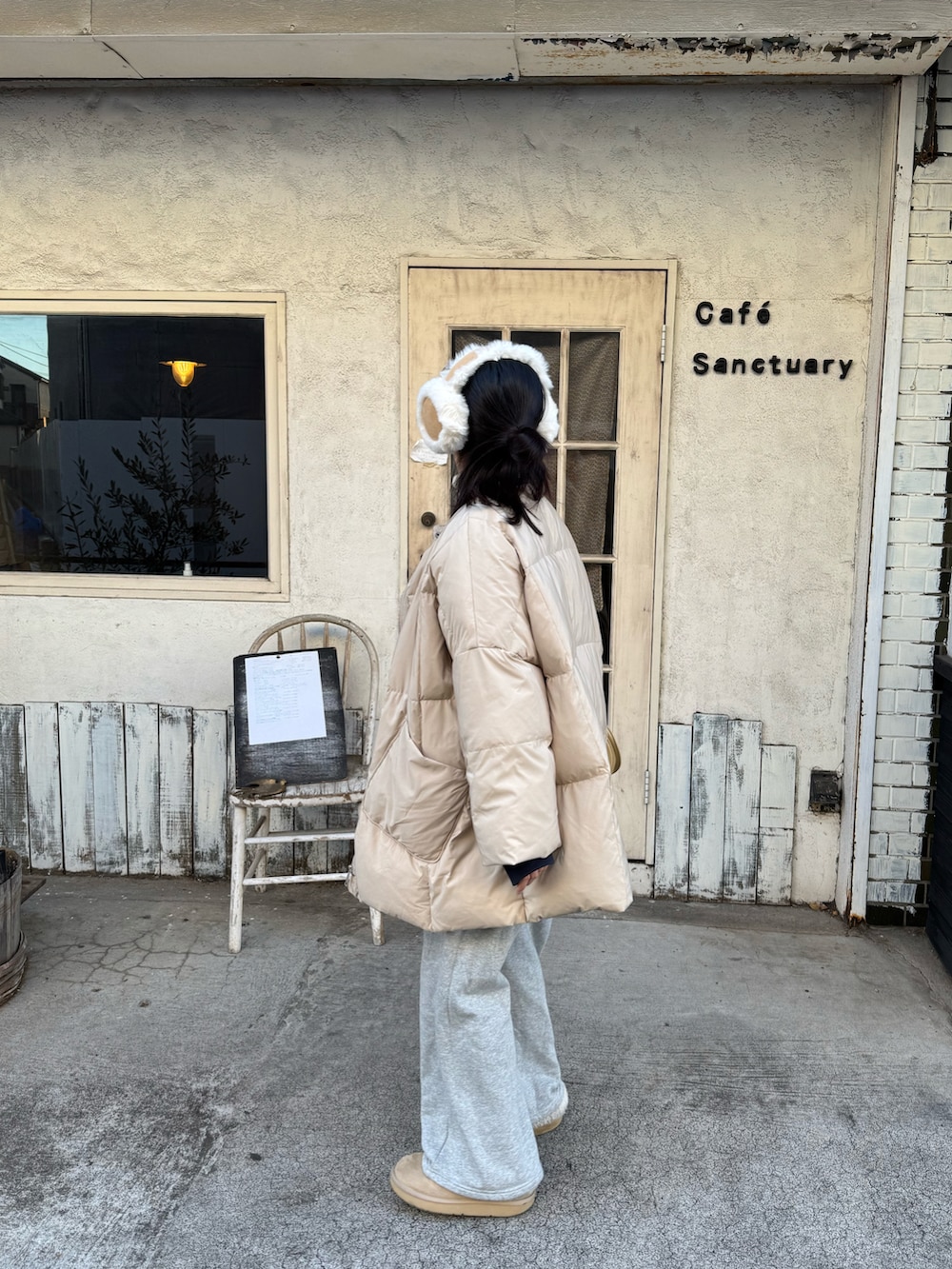 ブルー系のスウェット、ベージュ系のダウンジャケット/コート、イエロー系のトートバッグを着用したレディースの冬コーディネートの3枚目の写真