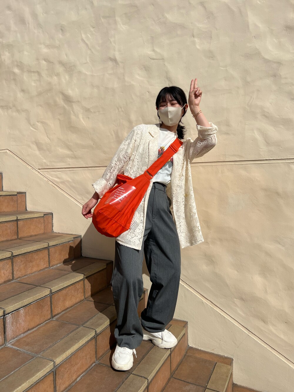 オレンジ系のショルダーバッグ、ホワイト系のTシャツ/カットソー、ホワイト系のテーラードジャケットを着用したレディースの春コーディネートの4枚目の写真