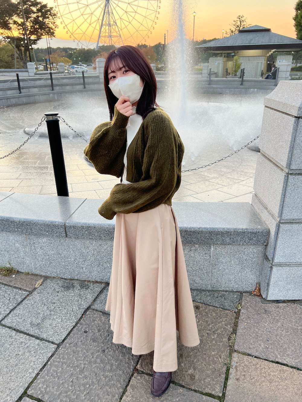 ベージュ系のスカート、グリーン系のカーディガン/ボレロ、ホワイト系のTシャツ/カットソーを着用したレディースの秋コーディネートの2枚目の写真