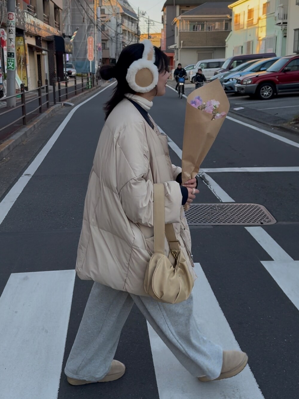 ブルー系のスウェット、ベージュ系のダウンジャケット/コート、イエロー系のトートバッグを着用したレディースの冬コーディネートの5枚目の写真