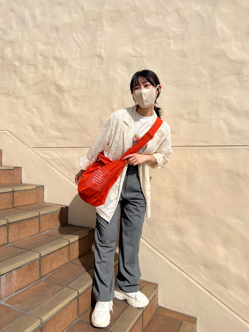 オレンジ系のショルダーバッグ、ホワイト系のTシャツ/カットソー、ホワイト系のテーラードジャケットを着用したレディースの春コーディネートの3枚目の写真