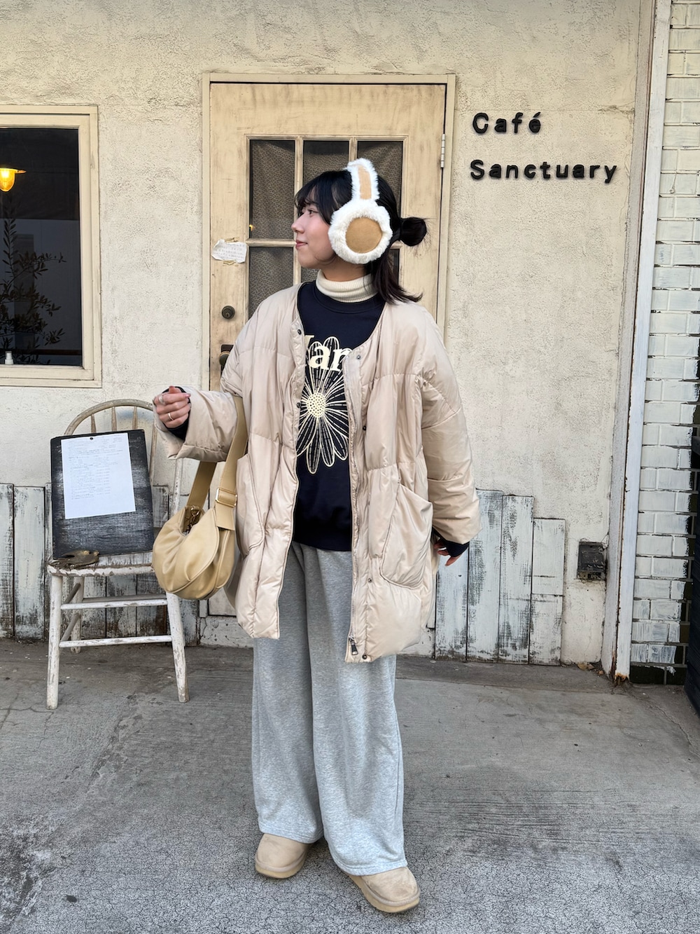 ブルー系のスウェット、ベージュ系のダウンジャケット/コート、イエロー系のトートバッグを着用したレディースの冬コーディネートの2枚目の写真