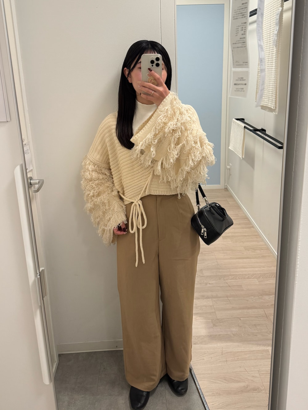 ベージュ系のその他パンツ、ホワイト系のニット/セーター、ブラック系のパンプスを着用したレディースの春コーディネートの2枚目の写真