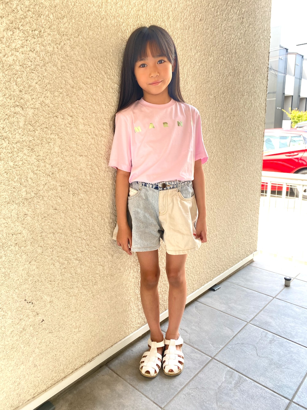 ブルー系のパンツ、ホワイト系のサンダル、ピンク系のTシャツ/カットソーを着用したキッズの夏コーディネートの2枚目の写真