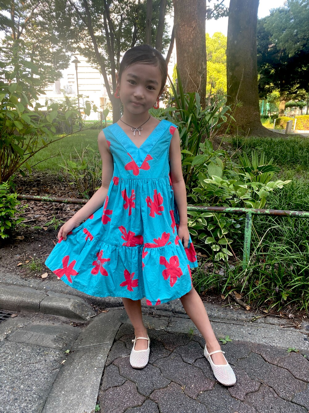 ブルー系のワンピース、ホワイト系のサンダルを着用したキッズの夏コーディネートの2枚目の写真