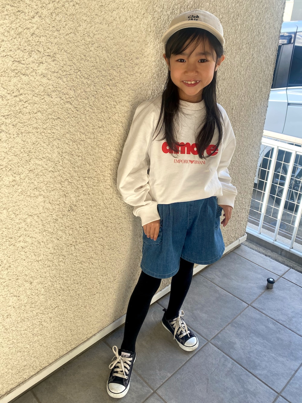 ホワイト系のトップス、ブルー系のデニムパンツ、ブラック系のスニーカーを着用したキッズの冬コーディネートの2枚目の写真