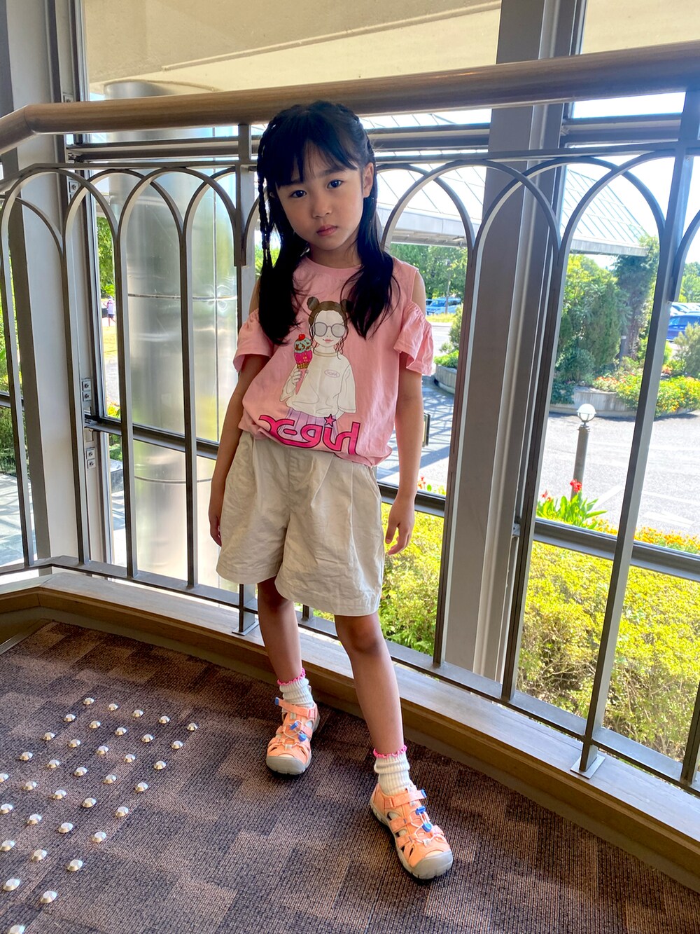 ピンク系のTシャツ/カットソー、ベージュ系のパンツ、ピンク系のサンダルを着用したキッズの夏コーディネートの2枚目の写真