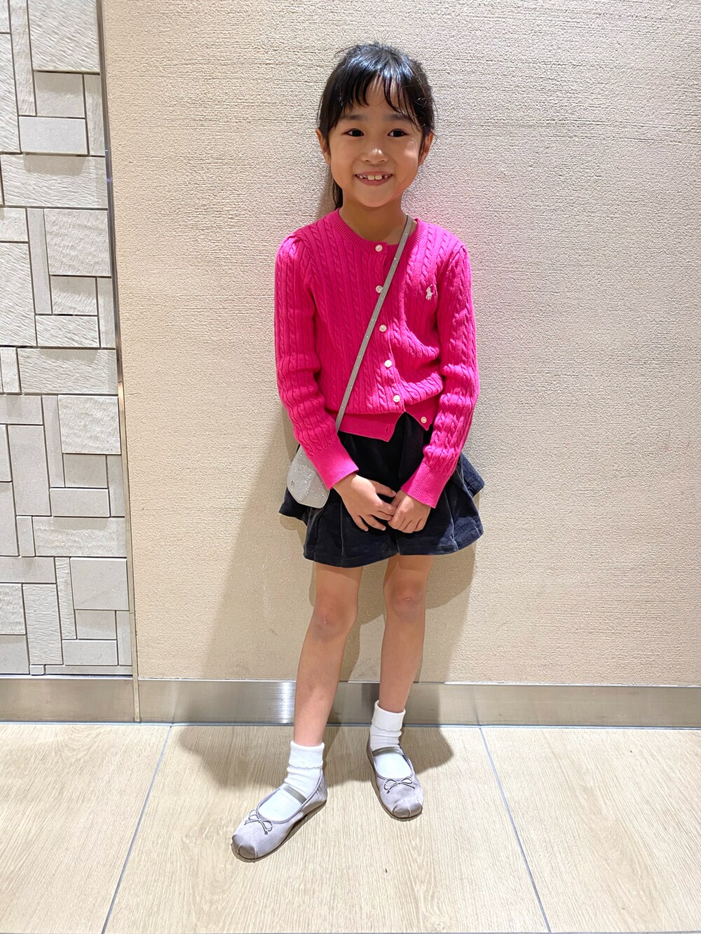 ピンク系のトップス、ブラック系のその他パンツ、シルバー系のシューズを着用したキッズの秋コーディネートの2枚目の写真