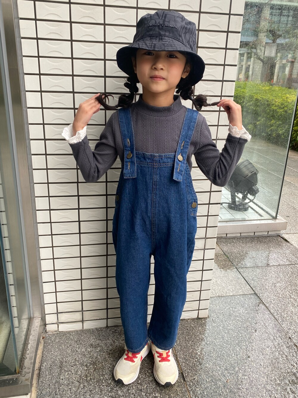 グレー系のトップス、ブルー系のオールインワン・サロペット、ベージュ系のスニーカーを着用したキッズの冬コーディネートの2枚目の写真