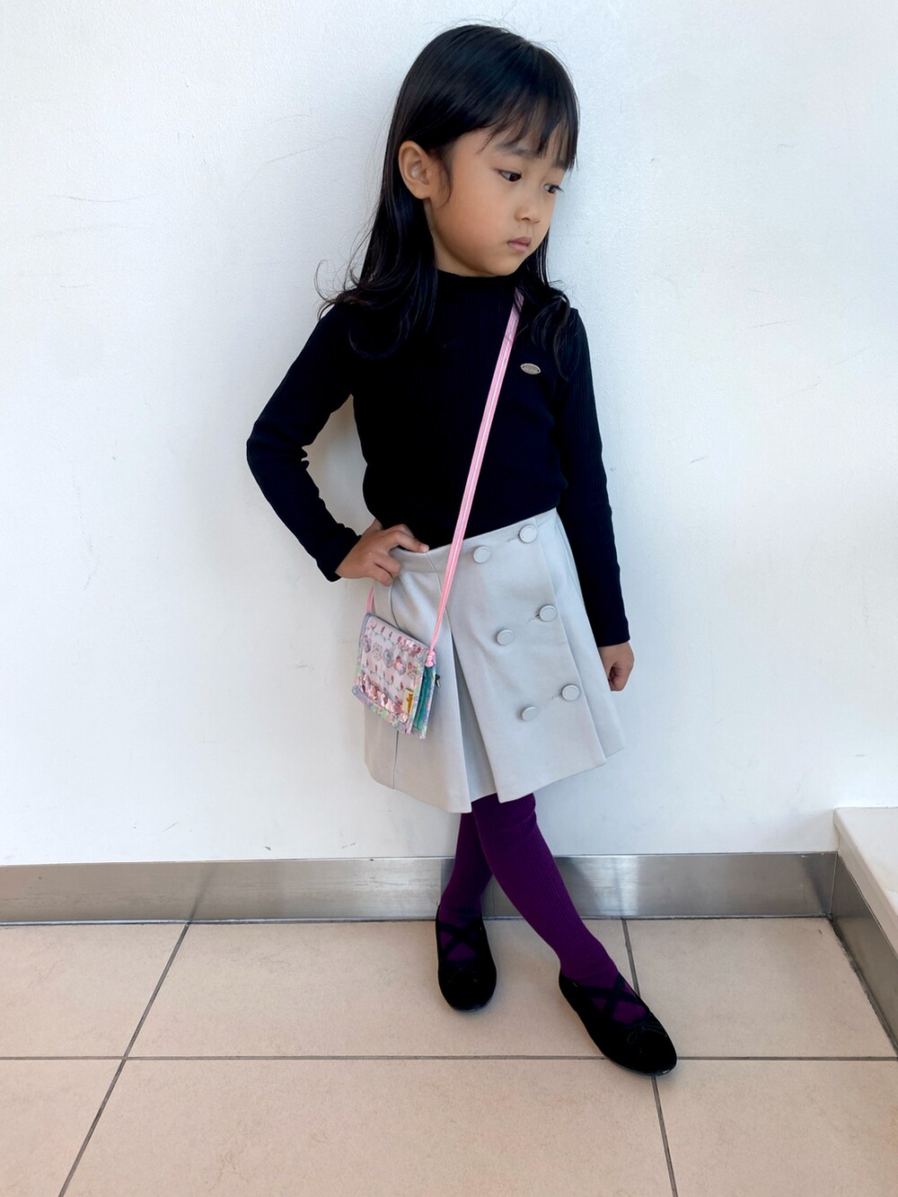 ホワイト系のスカート、ブラック系のバレエシューズ、ブラック系のTシャツ/カットソーを着用したキッズの秋コーディネートの2枚目の写真