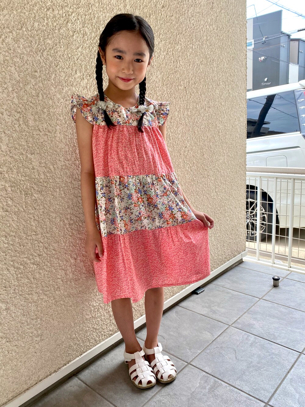 ピンク系のワンピース、ホワイト系のサンダルを着用したキッズの夏コーディネートの3枚目の写真