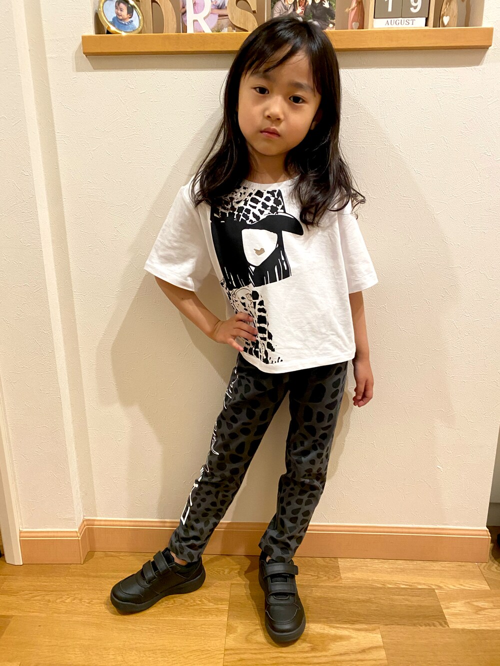 ブラック系のパンツ、ホワイト系のTシャツ/カットソー、ブラック系のスニーカーを着用したキッズの春コーディネートの2枚目の写真