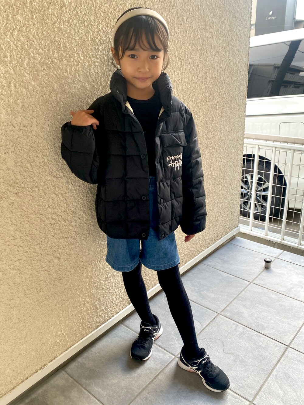 ブラック系のジャケット/アウター、ブラック系のニット/セーター、ブルー系のデニムパンツを着用したキッズの冬コーディネートの2枚目の写真