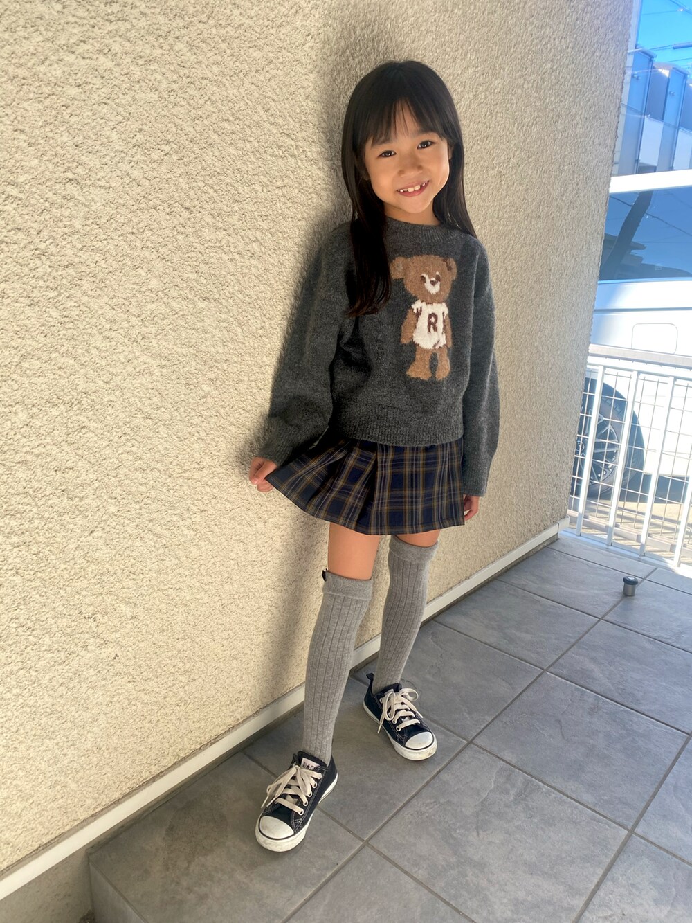 グレー系のニット/セーター、グリーン系のパンツ、ブラック系のスニーカーを着用したキッズの秋コーディネートの3枚目の写真