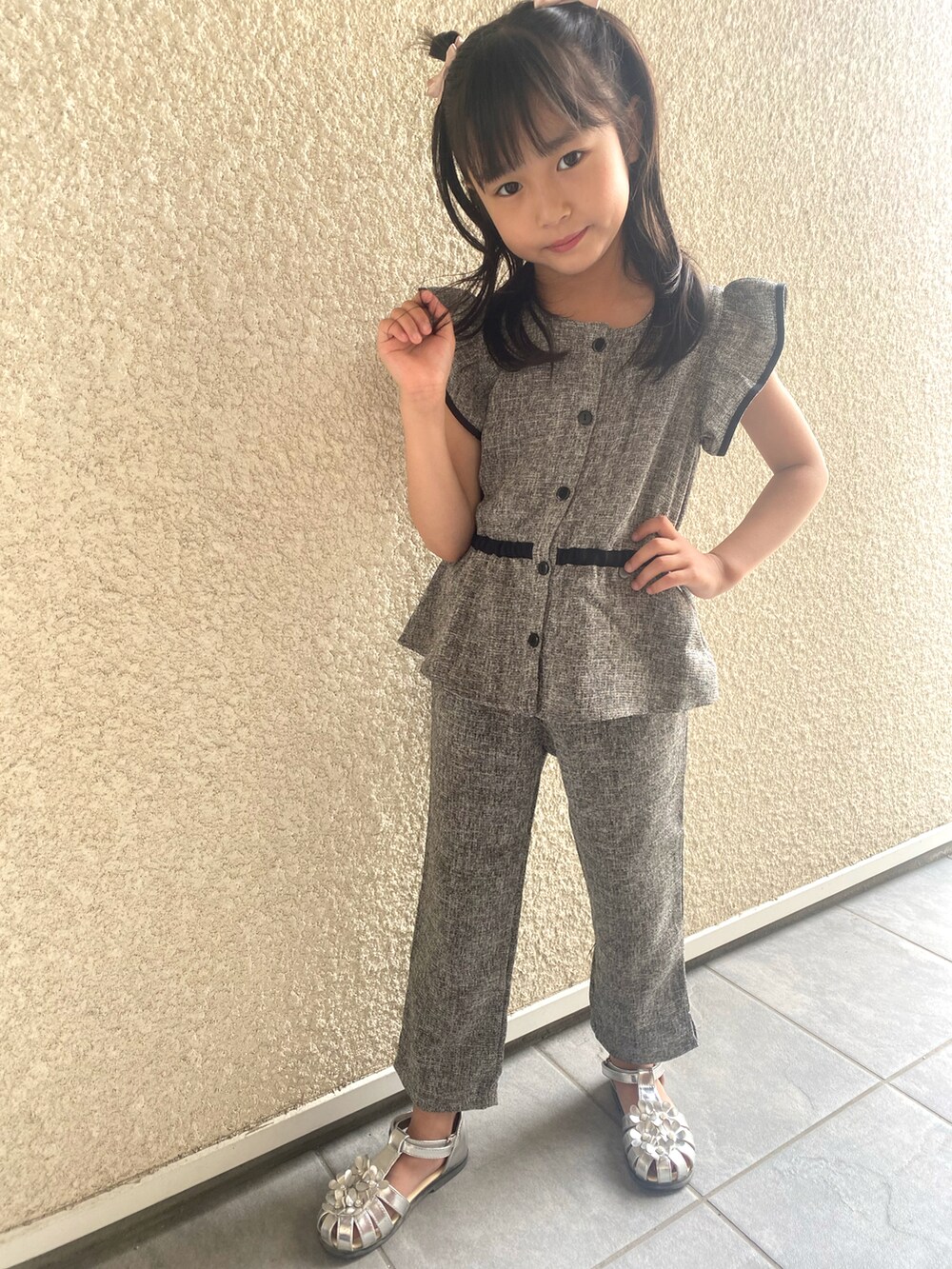 シルバー系のサンダル、ブラック系のセットアップを着用したキッズの夏コーディネートの3枚目の写真