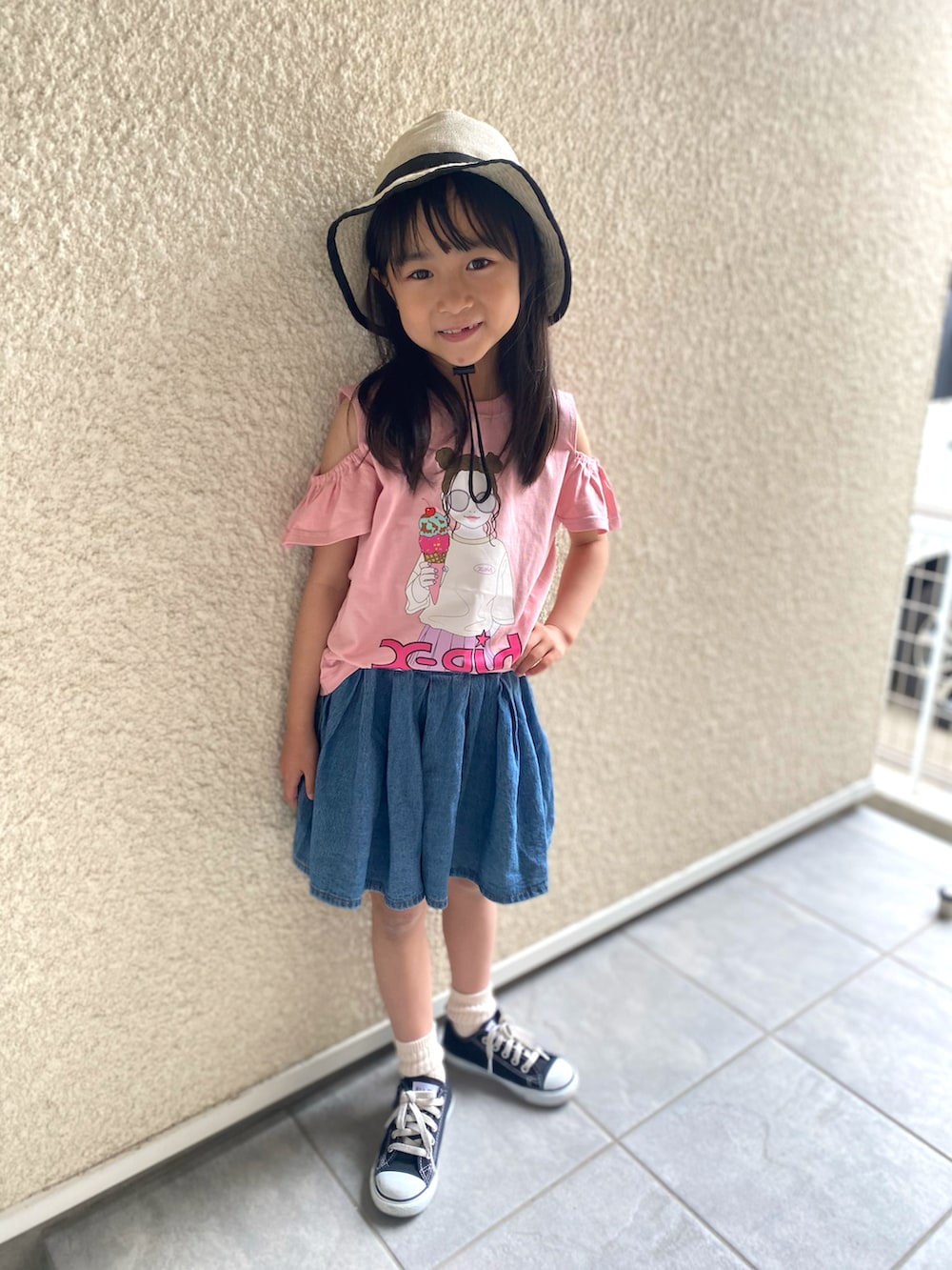 ピンク系のTシャツ/カットソー、ブルー系のデニムパンツ、ブラック系のスニーカーを着用したキッズの春コーディネートの2枚目の写真