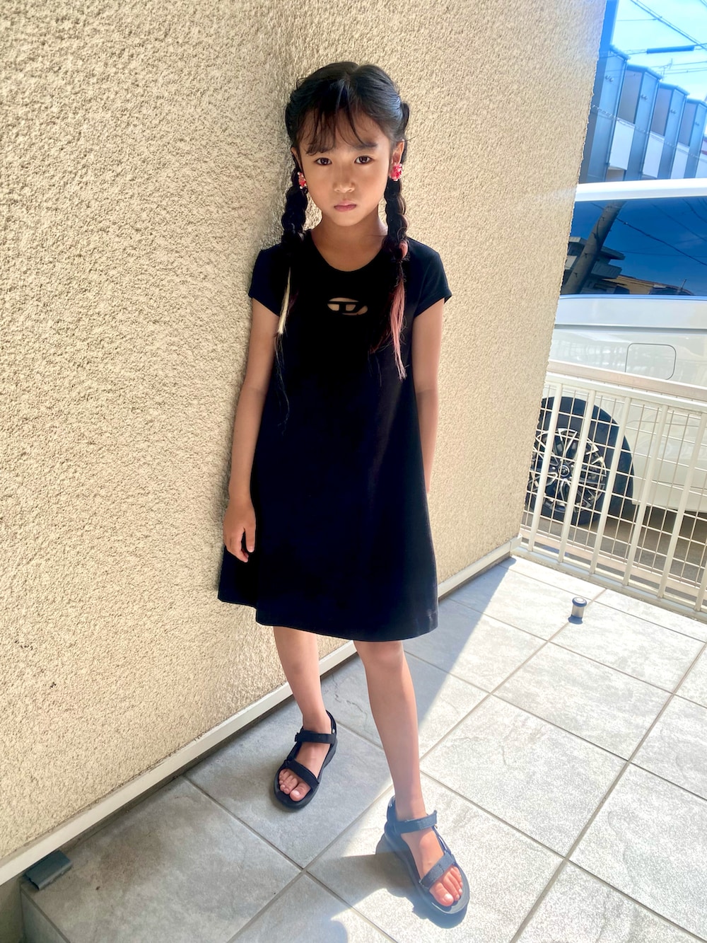 ブラック系のワンピース、ブラック系のサンダルを着用したキッズの夏コーディネートの3枚目の写真
