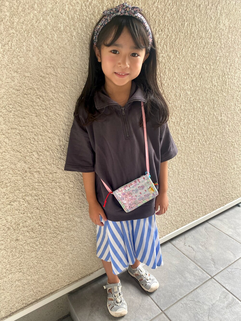 ホワイト系のスニーカー、ブルー系のスカート、グレー系のトップスを着用したキッズの夏コーディネートの2枚目の写真