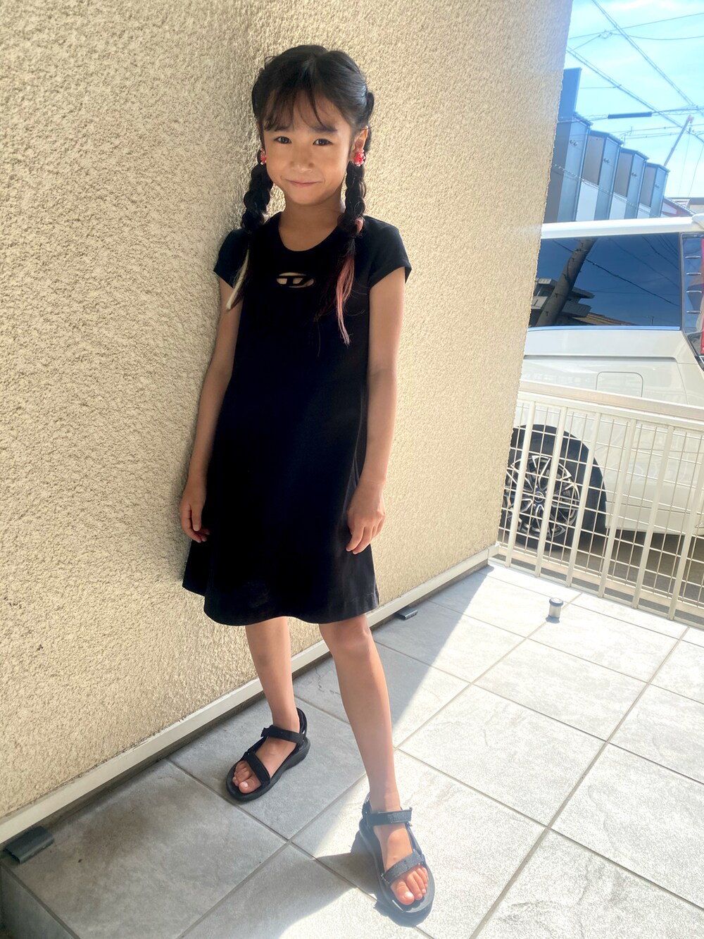 ブラック系のワンピース、ブラック系のサンダルを着用したキッズの夏コーディネートの2枚目の写真