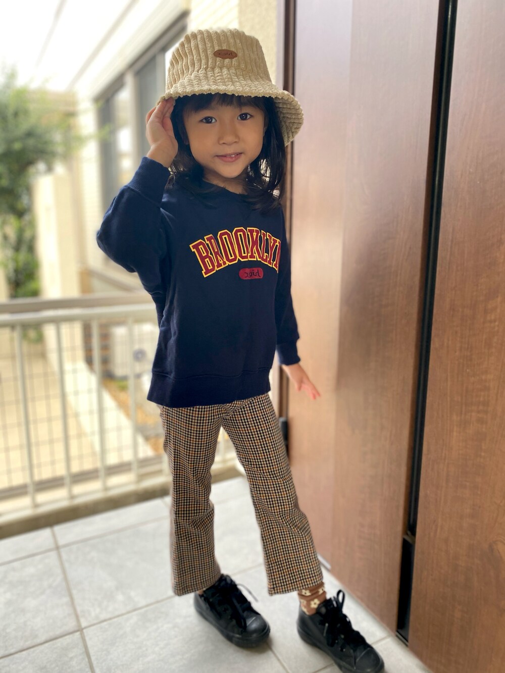 ブラウン系のパンツ、ブラック系のスニーカー、ブルー系のスウェットを着用したキッズの秋コーディネートの2枚目の写真