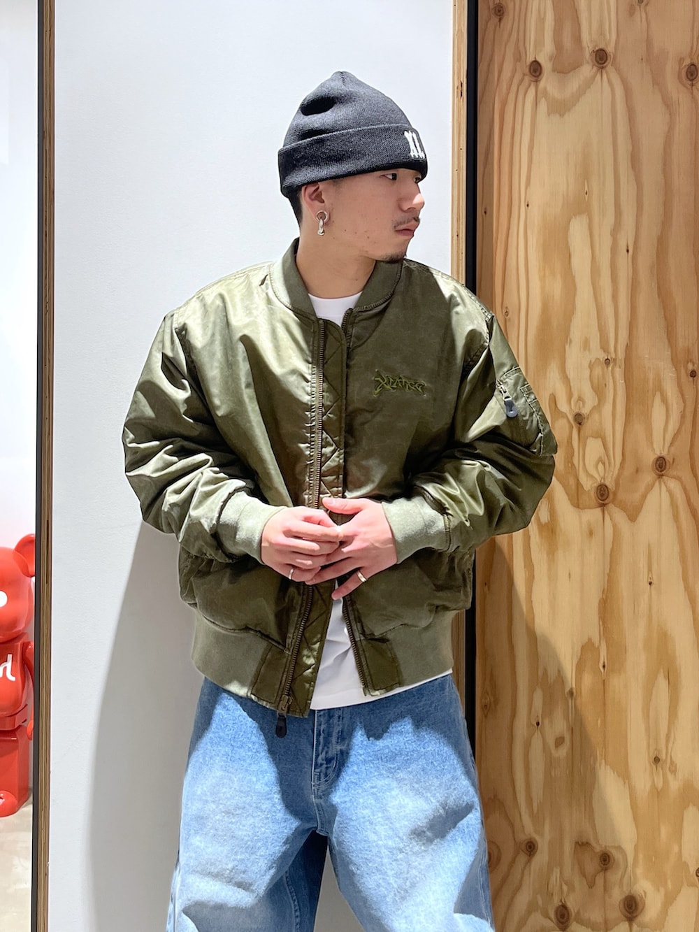 ホワイト系のTシャツ/カットソー、ブルー系のデニムパンツ、グリーン系のMA-1を着用したメンズの冬コーディネートの3枚目の写真