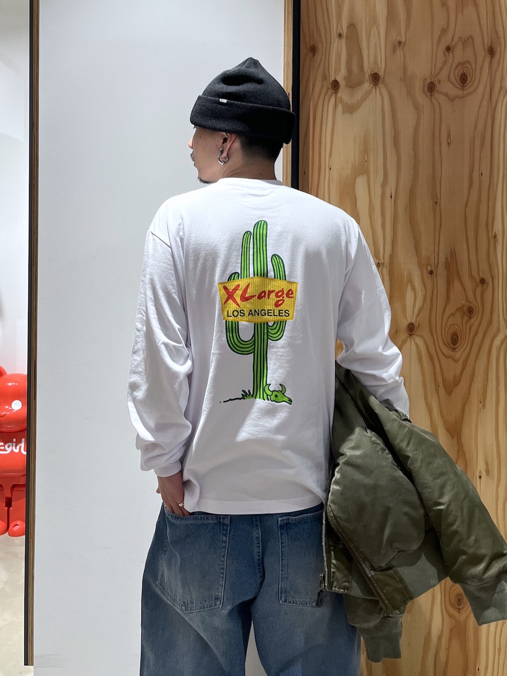 ホワイト系のTシャツ/カットソー、ブルー系のデニムパンツ、グリーン系のMA-1を着用したメンズの冬コーディネートの5枚目の写真