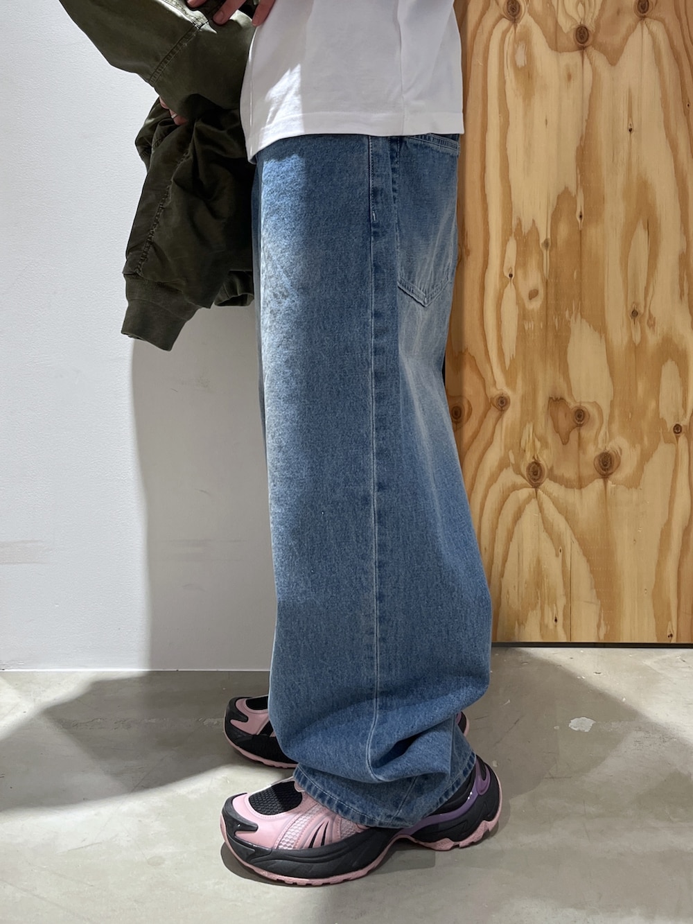 ホワイト系のTシャツ/カットソー、ブルー系のデニムパンツ、グリーン系のMA-1を着用したメンズの冬コーディネートの7枚目の写真