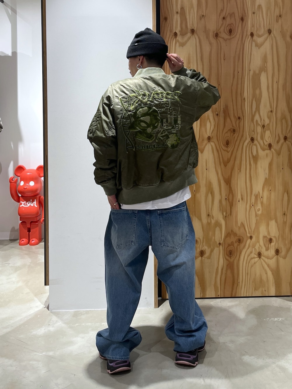 ホワイト系のTシャツ/カットソー、ブルー系のデニムパンツ、グリーン系のMA-1を着用したメンズの冬コーディネートの2枚目の写真