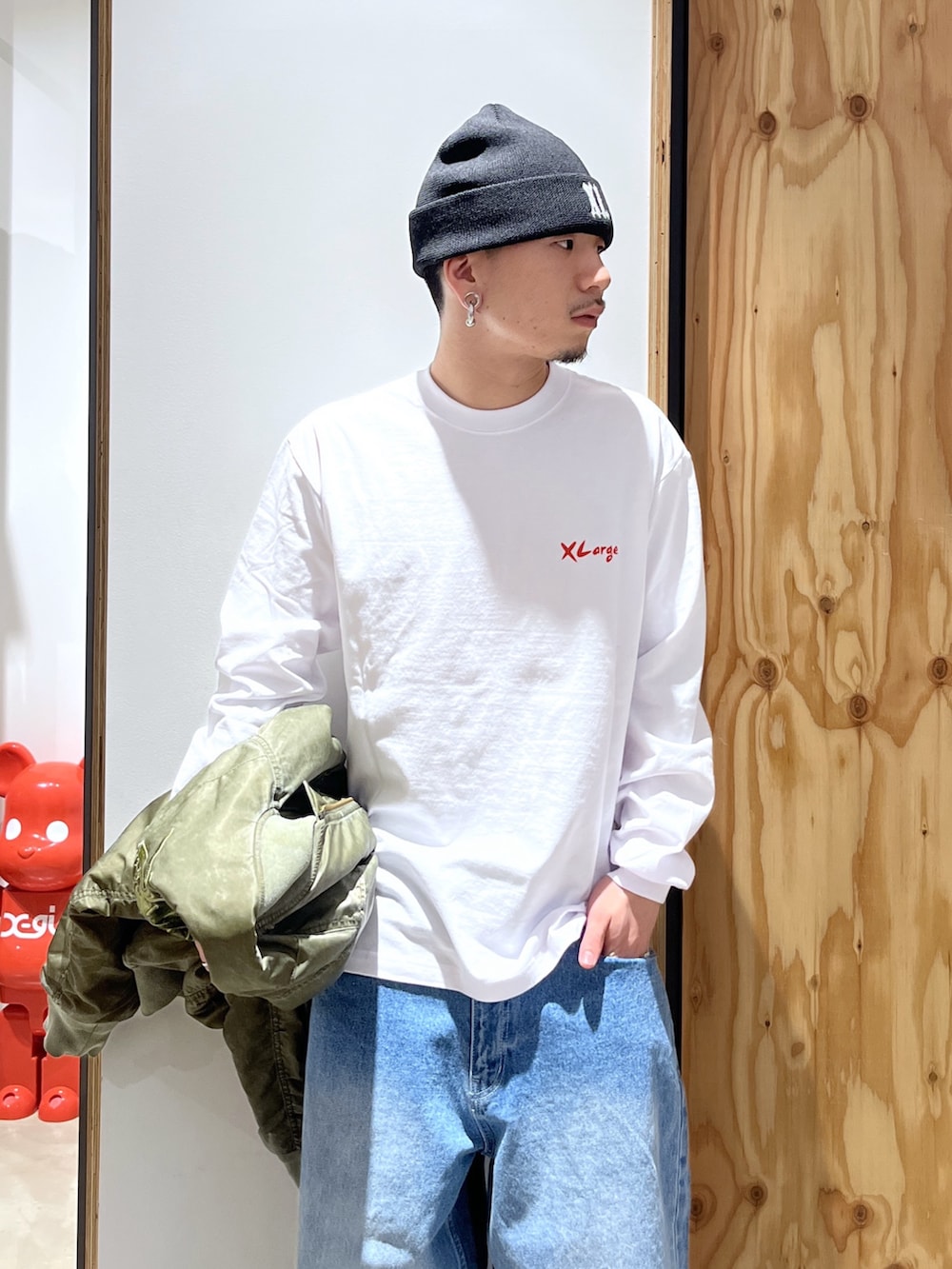 ホワイト系のTシャツ/カットソー、ブルー系のデニムパンツ、グリーン系のMA-1を着用したメンズの冬コーディネートの4枚目の写真