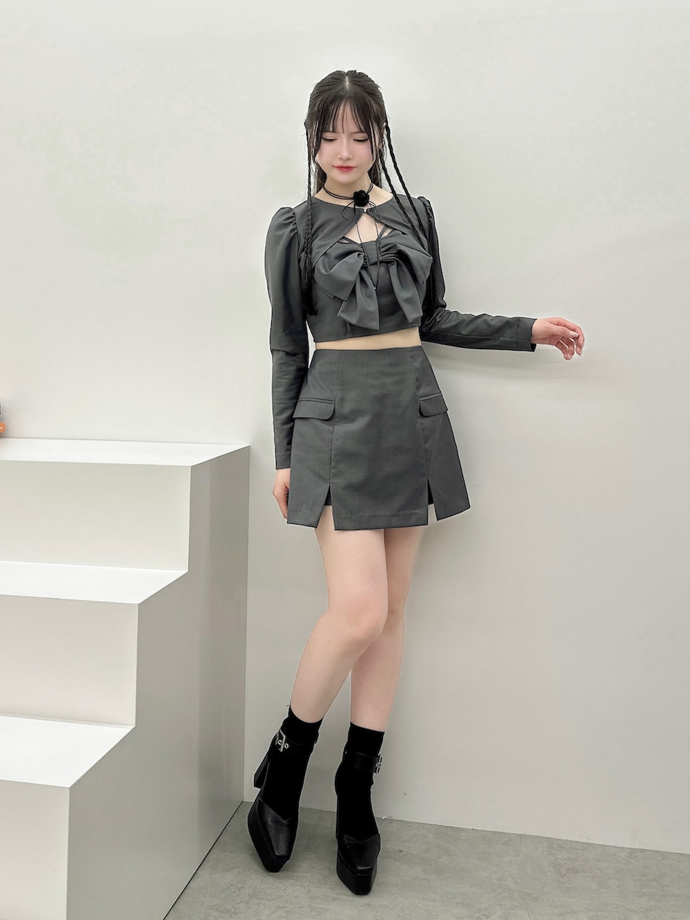 グレー系のワンピース、ブラック系のパンプス、ブラック系のバレッタ/ヘアクリップを着用したレディースの秋コーディネートの2枚目の写真